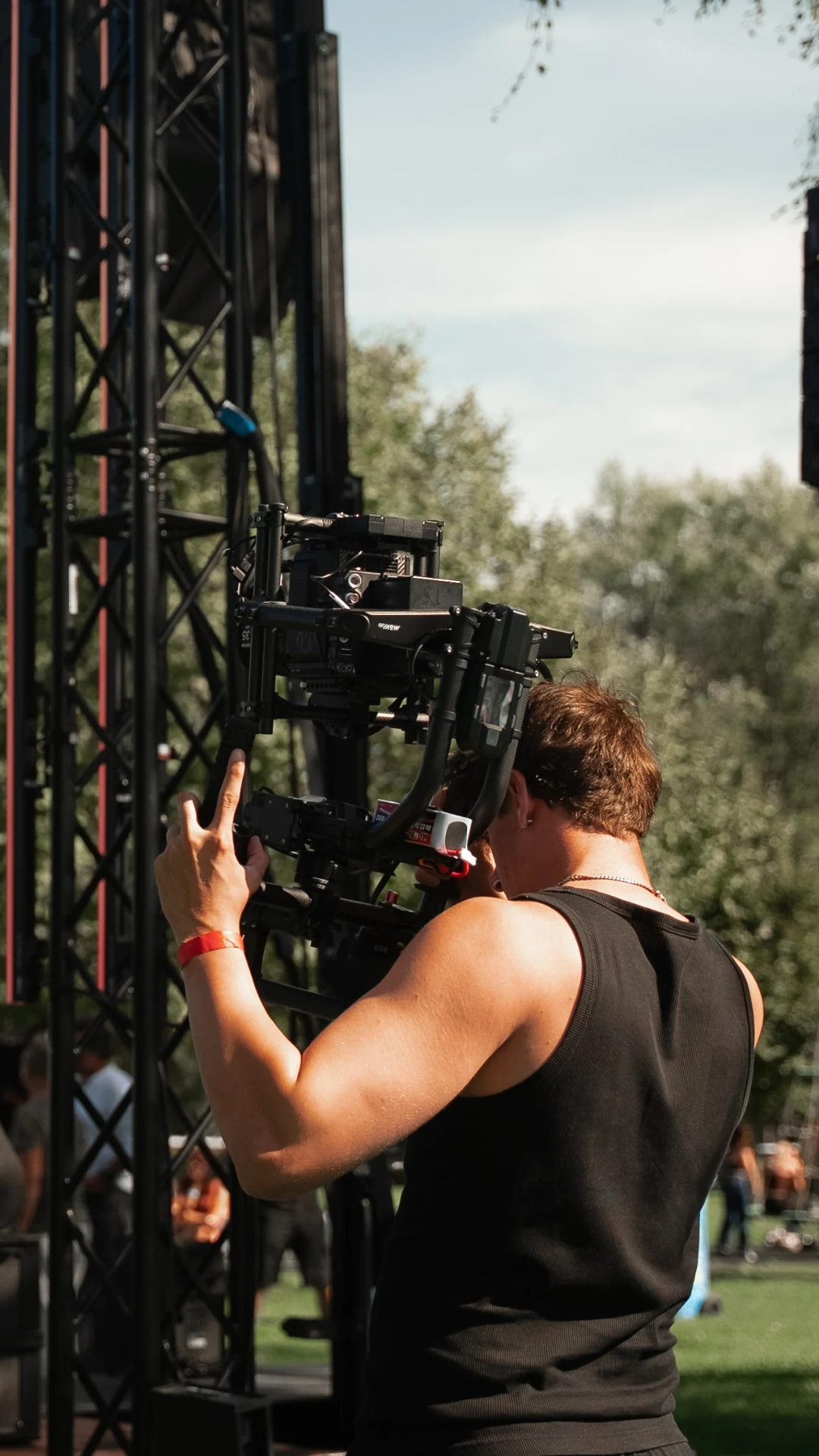 Kieran Steiner operating a cinema camera on a MōVI rig at a live stage.